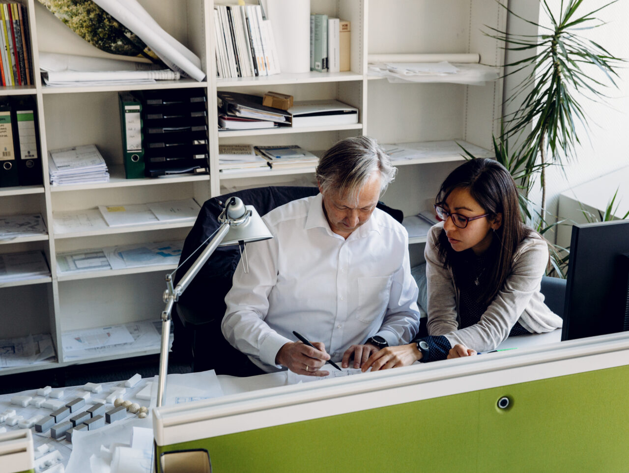 Erfahrener Architekt begleitet eine Kollegin bei der gemeinsamen Projektarbeit im Büro von Nattler Architekten.